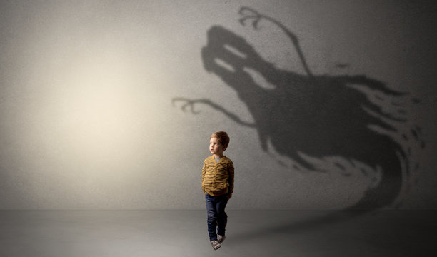 Scary ghost shadow in a dark empty room with a cute blond child

