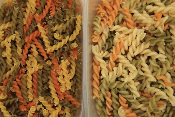 Three color spiral twist pasta, raw and boiled, for use as background.