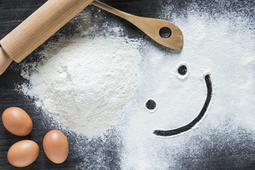 Baking background with a rolling pin, flour and raw eggs