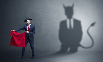 Businessman standing with red cloth in his hand and devil shadow on the background
