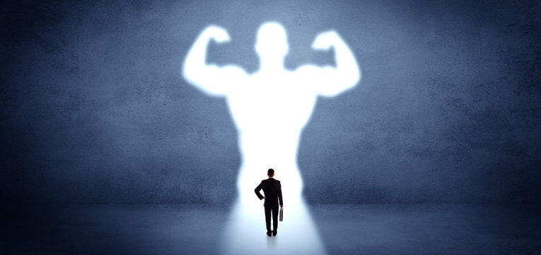 Businessman standing and dreaming about a strong superhero