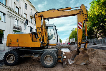 Excavator at road works. Excavations around pipeline for emergency repairs  in the city street. Heavy Duty construction equipment parked at construction site