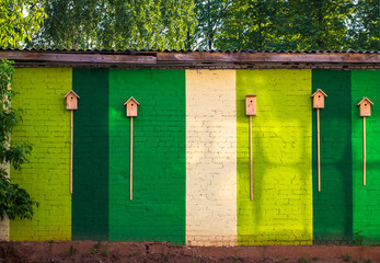 Wooden birdhouses on a multi-colored brick wall