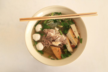 Asian rice noodle recipe, top view on white table.