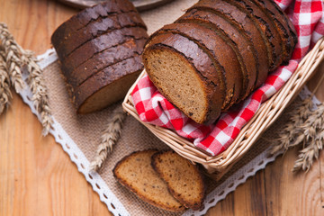 Sliced rye bread in a wicker basket and tablecloth 