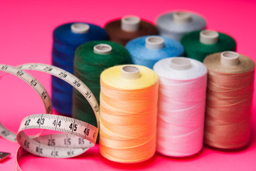 Pile of colorful spools of thread and measuring meter 