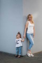 Mother and daughter outdoors in city. playing and having fun. Fashion happy mother and child daughter having fun together in the city