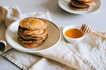 Banana pancakes with honey, honey dipper on a white background. Morning breakfast