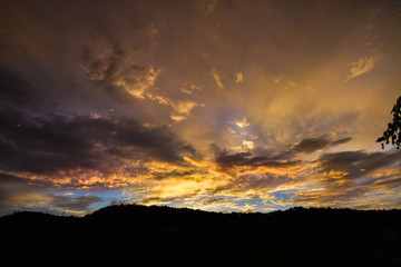 Dark dramatic clouds with golden horizon on the sky at dusk
