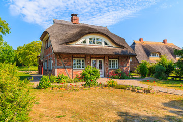 Fototapeta na wymiar Traditional house with straw roof and sunny blue sky in Middelhagen village, Ruegen island, Baltic Sea, Germany