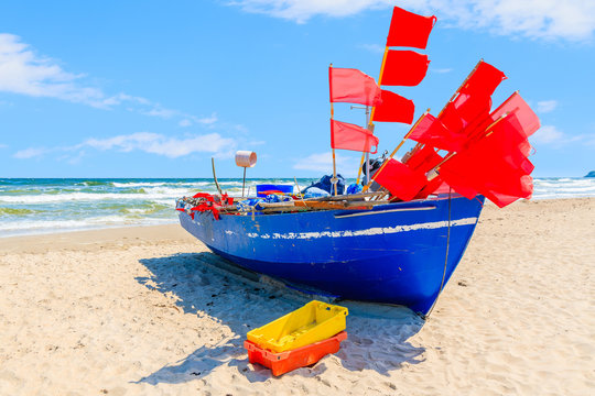 Traditional blue color fishing boat on sandy beach in Baabe summer resort, Ruegen island, Baltic Sea, Germany