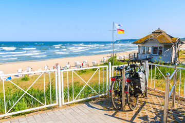 Obraz na płótnie Canvas SELLIN, RUEGEN ISLAND - MAY 29, 2018: Bicycle parked terrace overlooking beach in Sellin town on Baltic Sea coast, Germany. Ruegen is popular tourist destination because of its long sandy beaches.