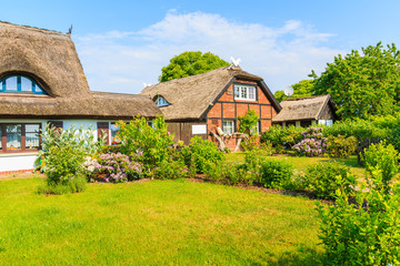 Fototapeta na wymiar Traditional houses with thatched roofs and sunny blue sky in Middelhagen village, Ruegen island, Baltic Sea, Germany