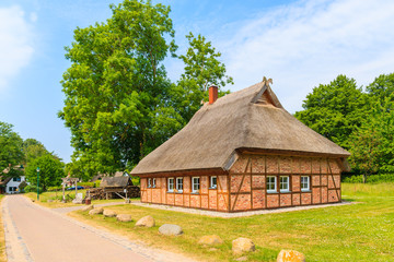 Fototapeta na wymiar Traditional house with thatched roof and sunny blue sky in Gross Stresow village, Ruegen island, Baltic Sea, Germany