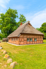 Fototapeta na wymiar Traditional house with thatched roof and sunny blue sky in Gross Stresow village, Ruegen island, Baltic Sea, Germany