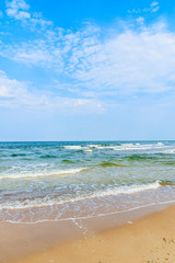Fototapeta na wymiar Sea waves on beach in Baabe summer resort from sand dune, Ruegen island, Baltic Sea, Germany