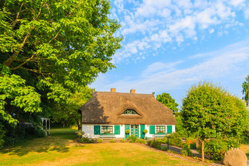 Fototapeta na wymiar Traditional house with straw roof and sunny blue sky near Seedorf village, Ruegen island, Baltic Sea, Germany