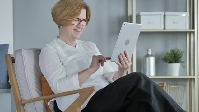 Online Video Chat on Tablet by Old Senior Woman Sitting on Couch