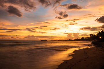 Beautiful and colorful sunset with gentle wave at calm beach in Bengal bay
