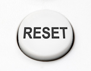 A white round button switch for reset close up. Control mechanical key for select idea of user on control device.