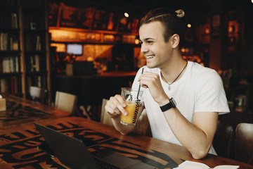 Smiling male drinking beverage in cafe