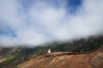 The church La Candelaria on a red hill with a big cloud, Frontera, El Golfo, El Hierro, Canary Islands, Spain