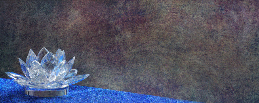 Rustic background with glass lotus tea light candle - dark rustic grunge background with a clear cut glass lotus tea light candle holder on left and plenty of copy space 
