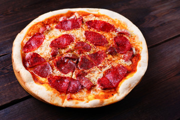 Classical sliced appetizing pepperoni pizza close up. Traditional Italian cuisine, popular snack. Food delivery, pizzeria, recipe, restaurant concept