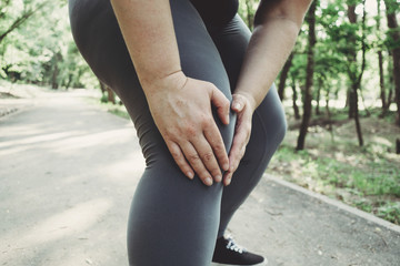 Woman touching her leg, got a knee trauma at outdoor jogging. Sports injury, health care, sports,...