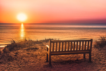 Fototapeta na wymiar Empty bench near the beach at sunset on the island of Sylt