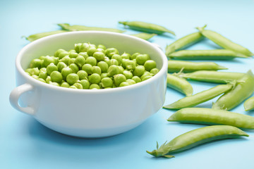 Fresh green peas in a white bowl. Organic product, veganism and vegetarianism