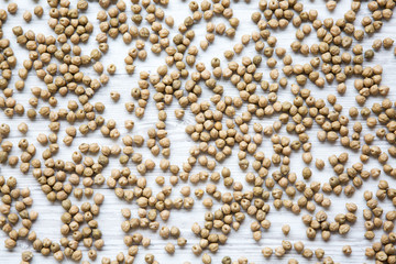 Dried chickpeas on white wooden table, top view.