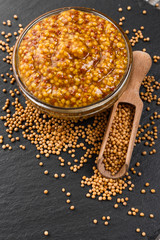mustard in a bowl on a rustic background