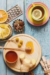 Cups with herb tea and pieces of lemon on the wooden background