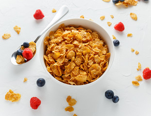 Morning healthy Breakfast honey Cornflakes with fresh fruits of Raspberry, blueberries