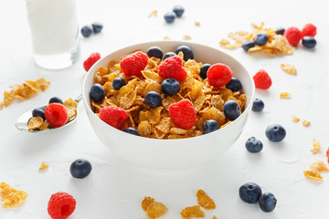 Morning healthy Breakfast honey Cornflakes with fresh fruits of Raspberry, blueberries