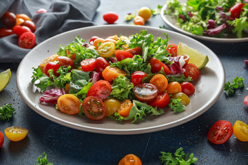 Fresh Cherry Tomato mix salad with lettuce, lemon, lime, black pepper and sea salt. healthy food