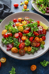 Fresh Cherry Tomato mix salad with lettuce, lemon, lime, black pepper and sea salt. healthy food