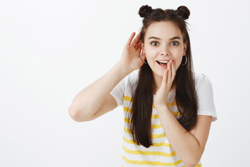Tell me every nasty detail. Excited joyful stylish woman with hairbuds, bending towards camera and...
