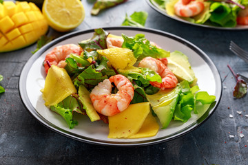 Fresh Shrimps, Avocado, Mango salad with lettuce green mix, herbs, lemon, healthy food.