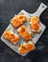 Homemade Crispbread toast with Smoked Salmon and soft chees, chives on white board