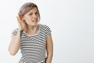 Repeat louder, cannot hear your whisper. Portrait of intense confused attractive female student in...