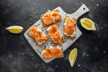 Homemade Crispbread toast with Smoked Salmon and soft chees, chives on white board