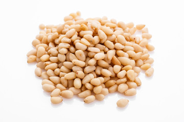 peeled pine nuts on a white acrylic background