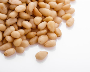 peeled pine nuts on a white acrylic background