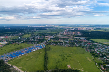 Aerial view of wheat fields, meadow, forest and village in rural Russia.
