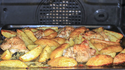 Fried potatoes with chicken with golden crust in the oven
