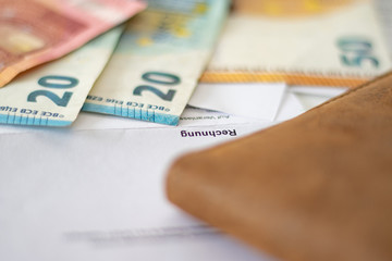Weiße Rechnung zwischen verschiedenen Euro Geldscheinen auf einem Schreibtisch