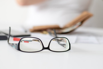 Blick auf den Schreibtisch einer Businessfrau in einer Bankfiliale mit einer modernen Brille im...