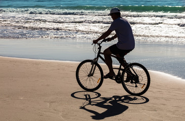 Fototapeta na wymiar Silhueta de ciclista na praia
